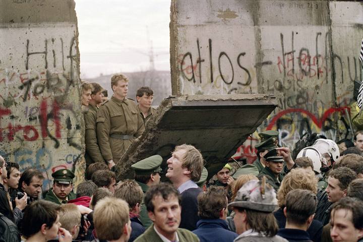 (FILES) - Picture taken on November 11, 1989 shows West Berliners crowd in front of the Berlin Wall as they watch East German border guards demolishing a section of the wall in order to open a new crossing point between East and West Berlin, near the Potsdamer Platz. Germany on November 7, 2014 kicks off a weekend of celebrations marking the 25th anniversary of the epochal fall of the Berlin Wall with millions expected to descend on the reunited capital. AFP PHOTO / GERARD MALIE